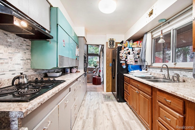 5178 Helga St, Saginaw, MI 48603 - kitchen featuring black appliances, under cabinet range hood, light countertops, tasteful backsplash, and light wood-style floors
