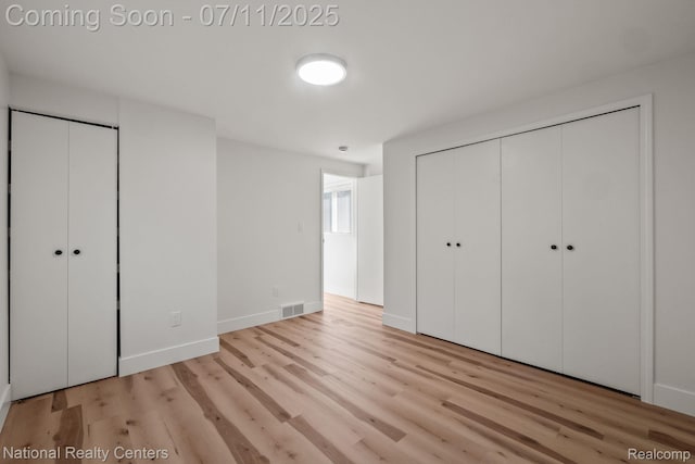 1089 Tecumseh Ave, Waterford, MI 48327 - unfurnished bedroom with wood finished floors and multiple closets