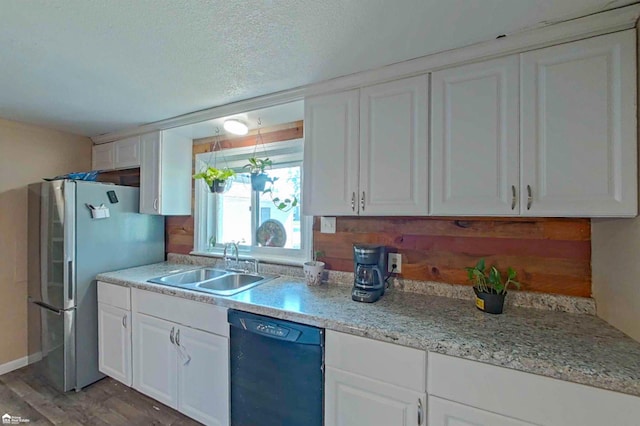 296 S Saginaw St, Montrose, MI 48457 - kitchen featuring dishwasher, freestanding refrigerator, white cabinets, a textured ceiling, and wood finished floors