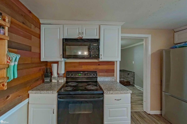 296 S Saginaw St, Montrose, MI 48457 - kitchen with black appliances, white cabinets, light wood-style floors, wooden walls, and open shelves