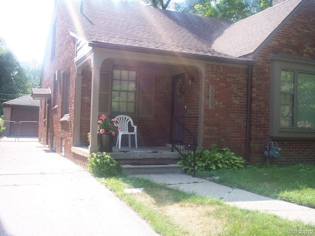 20003 Lichfield Rd, Detroit, MI 48221 - view of front facade featuring brick siding, a porch, and a shingled roof