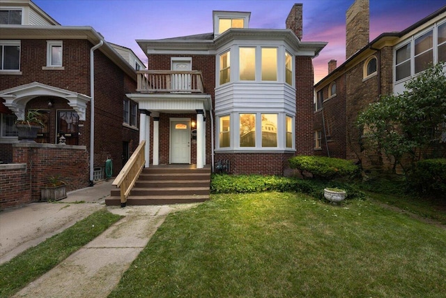 2475 Hazelwood St, Detroit, MI 48206 - view of front facade with a balcony, a front lawn, brick siding, and a chimney