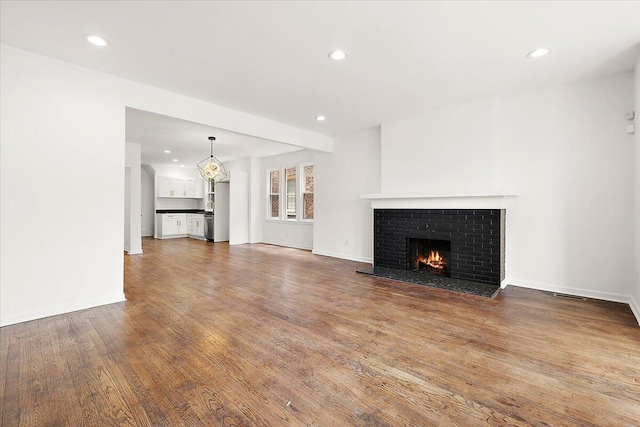 2475 Hazelwood St, Detroit, MI 48206 - unfurnished living room with a brick fireplace, wood finished floors, and recessed lighting