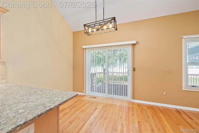 57349 Megan Dr, Washington, MI 48094 - unfurnished dining area with a chandelier, light wood finished floors, and high vaulted ceiling
