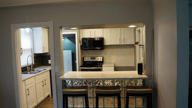 13558 Asbury Park, Detroit, MI 48227 - kitchen with electric stove, backsplash, and white cabinetry