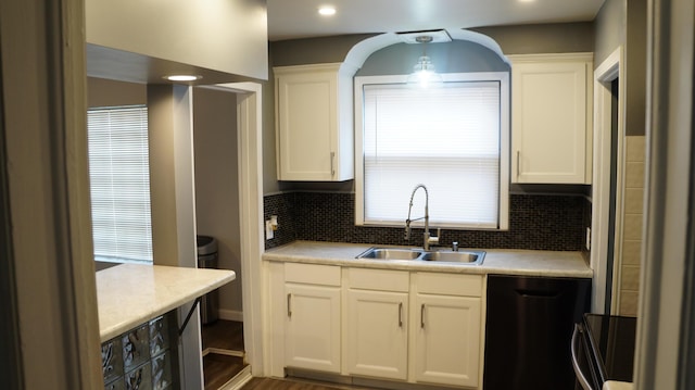 13558 Asbury Park, Detroit, MI 48227 - kitchen featuring dishwashing machine, white cabinets, light countertops, and decorative backsplash