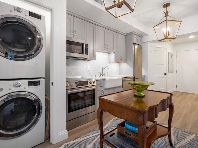 111 N Ashley St Unit 513, Ann Arbor, MI 48104 - kitchen with stainless steel appliances, stacked washer / dryer, gray cabinetry, and recessed lighting