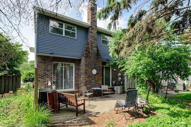 2746 Page Ave, Ann Arbor, MI 48104 - rear view of house with brick siding, a patio, and a chimney