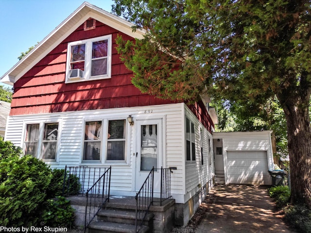 892 W Forest Ave, Muskegon, MI 49441 - view of front of property with an outbuilding, a detached garage, cooling unit, and asphalt driveway