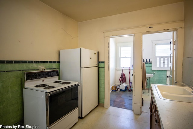 892 W Forest Ave, Muskegon, MI 49441 - kitchen featuring white appliances, tile walls, light floors, and wainscoting
