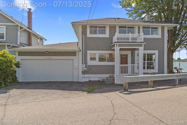 106 St Clair River Dr, Algonac, MI 48001 - view of front of home with an attached garage, asphalt driveway, a balcony, and roof with shingles