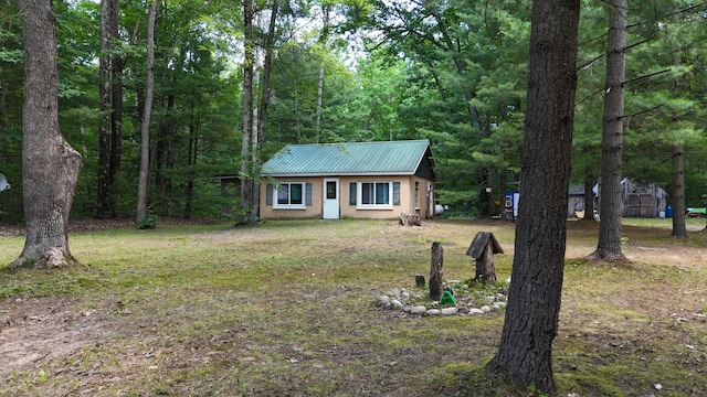 17644 Stronach Dam Rd, Wellston, MI 49689 - view of front of home with a metal roof and a forest view