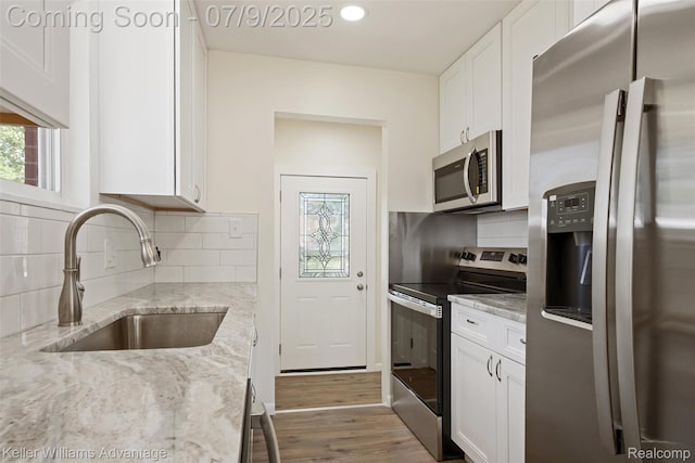 44249 Donley Dr, Sterling Heights, MI 48314 - kitchen with appliances with stainless steel finishes, white cabinetry, wood finished floors, tasteful backsplash, and recessed lighting