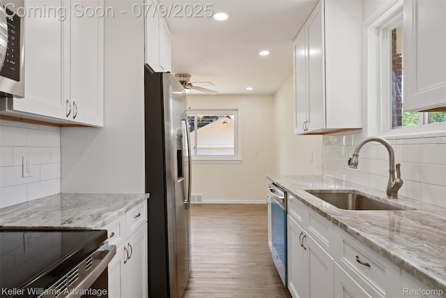 44249 Donley Dr, Sterling Heights, MI 48314 - kitchen featuring appliances with stainless steel finishes, white cabinetry, wood finished floors, decorative backsplash, and recessed lighting