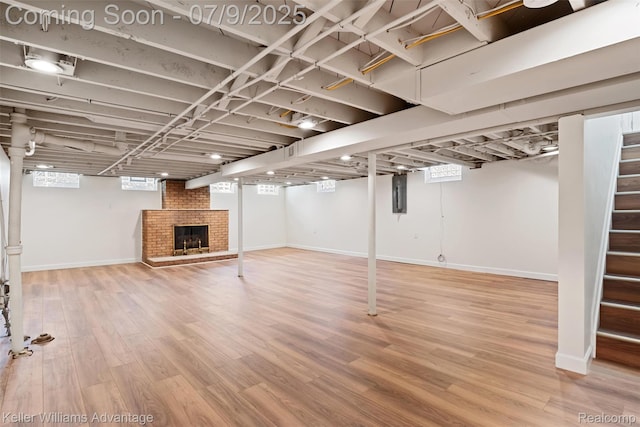 44249 Donley Dr, Sterling Heights, MI 48314 - basement with stairway, a brick fireplace, electric panel, and wood finished floors