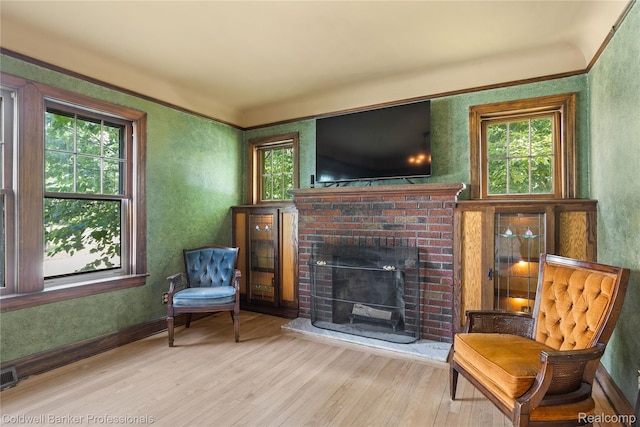 122 Linden Ct, Ypsilanti, MI 48197 - sitting room featuring plenty of natural light, wood finished floors, a brick fireplace, and crown molding