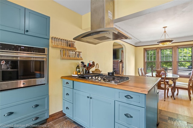 122 Linden Ct, Ypsilanti, MI 48197 - kitchen featuring appliances with stainless steel finishes, wood counters, island range hood, and blue cabinetry