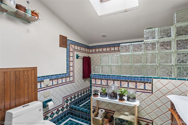 122 Linden Ct, Ypsilanti, MI 48197 - bathroom featuring a skylight, vaulted ceiling, and tiled shower