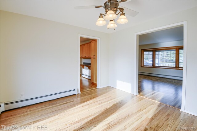 11247 Irish Rd, Otisville, MI 48463 - empty room with a baseboard heating unit, wood finished floors, baseboard heating, and ceiling fan