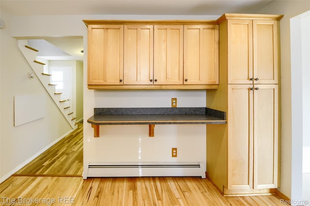 11247 Irish Rd, Otisville, MI 48463 - kitchen with a baseboard heating unit, dark countertops, light wood-style floors, and light brown cabinets