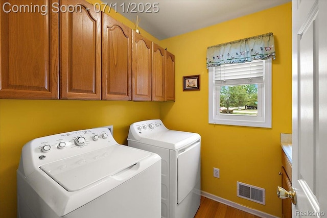54561 Laurel Dr, Macomb, MI 48042 - washroom featuring cabinet space, washer and dryer, and wood finished floors