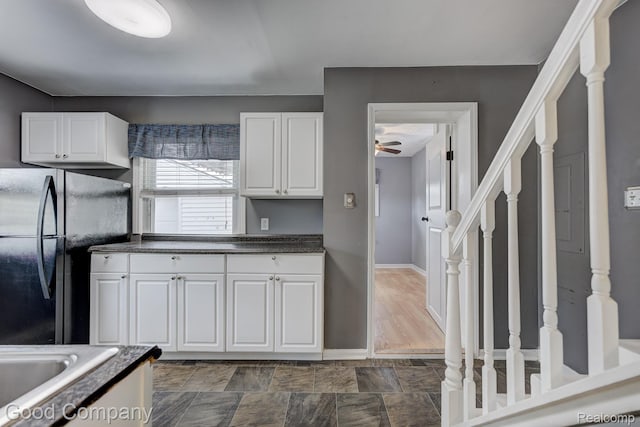 1977 Princeton Rd, Troy, MI 48072 - kitchen with freestanding refrigerator, ceiling fan, dark countertops, and white cabinetry