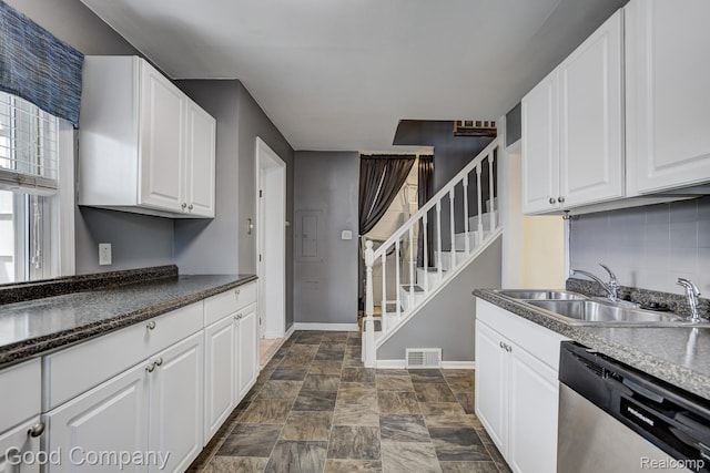 1977 Princeton Rd, Troy, MI 48072 - kitchen with stainless steel dishwasher, stone finish flooring, white cabinetry, and decorative backsplash