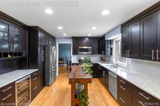 4247 Morningview Dr, Shelby Twp, MI 48316 - kitchen featuring appliances with stainless steel finishes, wine cooler, light stone countertops, decorative backsplash, and recessed lighting