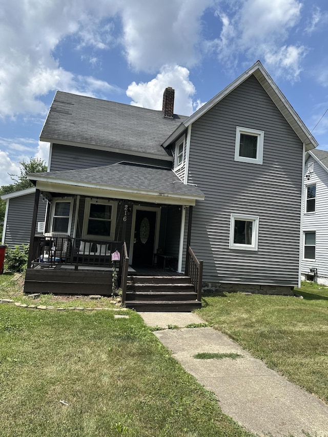 216 N Dwight St, Jackson, MI 49202 - view of front of home featuring covered porch, a front yard, a chimney, and roof with shingles