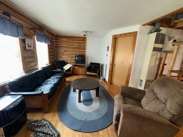 3786 W Houghton Lake Dr, Houghton Lake, MI 48629 - living area with log walls, light wood-style floors, and a heating unit