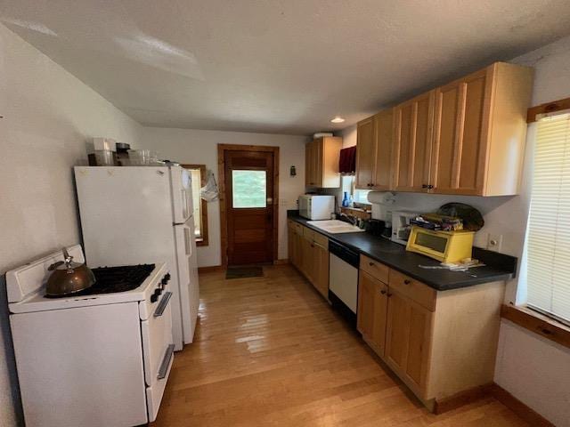 3786 W Houghton Lake Dr, Houghton Lake, MI 48629 - kitchen featuring white appliances, light wood-type flooring, and dark countertops