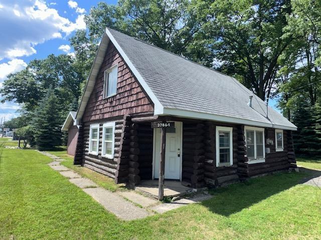 3786 W Houghton Lake Dr, Houghton Lake, MI 48629 - log cabin featuring log siding, a front yard, and roof with shingles