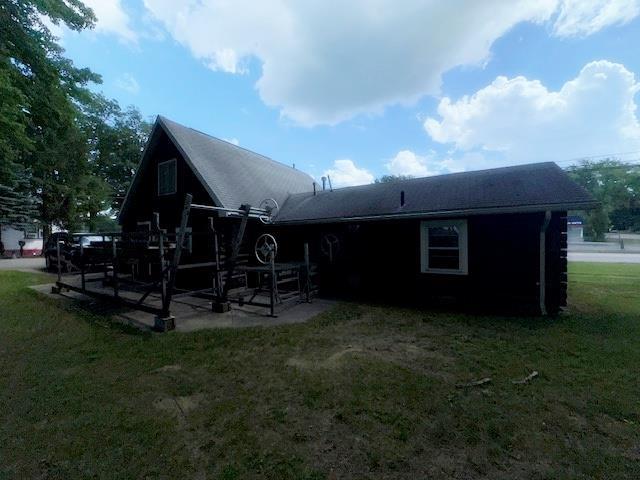 3786 W Houghton Lake Dr, Houghton Lake, MI 48629 - rear view of property with a patio area and a yard