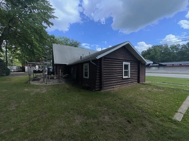 3786 W Houghton Lake Dr, Houghton Lake, MI 48629 - view of home's exterior featuring log exterior, a lawn, and a patio