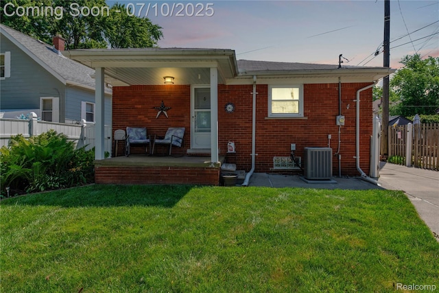 144 1st St, Wyandotte, MI 48192 - back of property at dusk with a porch and brick siding