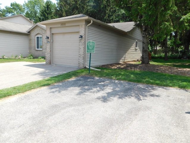 36561 S Deerhurst S, Westland, MI 48185 - view of side of home featuring a garage, asphalt driveway, and brick siding