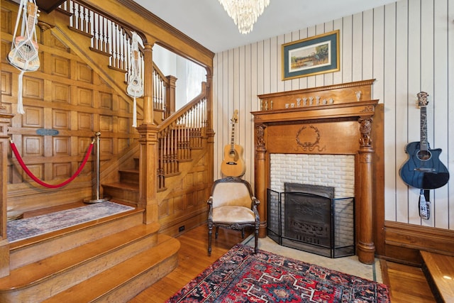 501 E Michigan Ave, Marshall, MI 49068 - living area featuring stairway, hardwood / wood-style flooring, a fireplace, a chandelier, and wooden walls