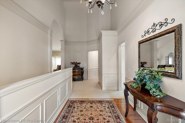 838 Knolls Landing Dr Unit 6, Milford, MI 48381 - hallway with a high ceiling, ornate columns, wainscoting, a chandelier, and a decorative wall