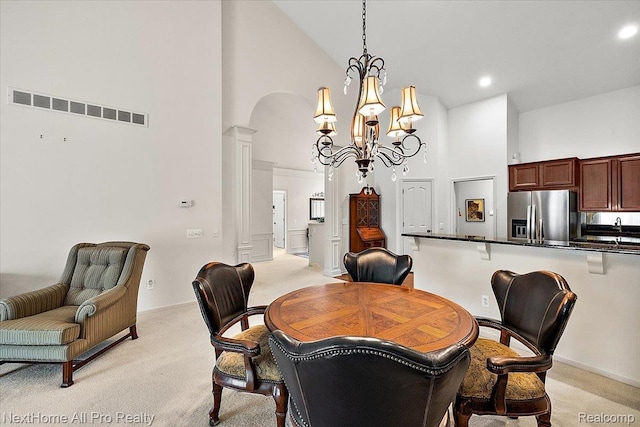 838 Knolls Landing Dr Unit 6, Milford, MI 48381 - dining room with high vaulted ceiling, light colored carpet, a chandelier, arched walkways, and recessed lighting