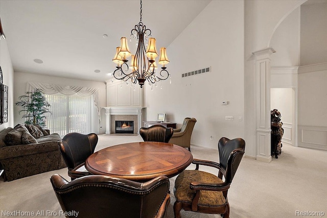 838 Knolls Landing Dr Unit 6, Milford, MI 48381 - carpeted dining space with a premium fireplace, ornate columns, high vaulted ceiling, and a chandelier
