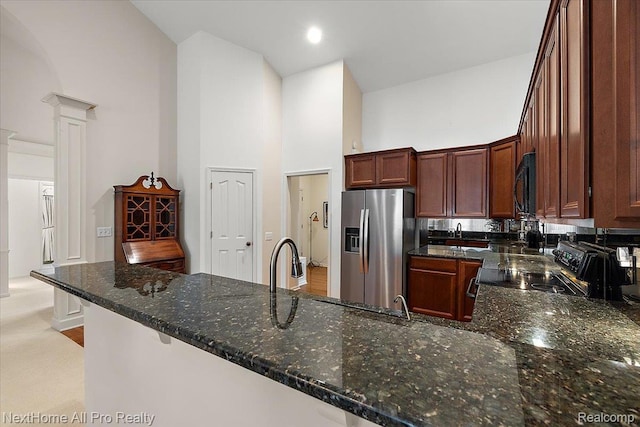838 Knolls Landing Dr Unit 6, Milford, MI 48381 - kitchen with stainless steel refrigerator with ice dispenser, high vaulted ceiling, black microwave, electric range, and ornate columns