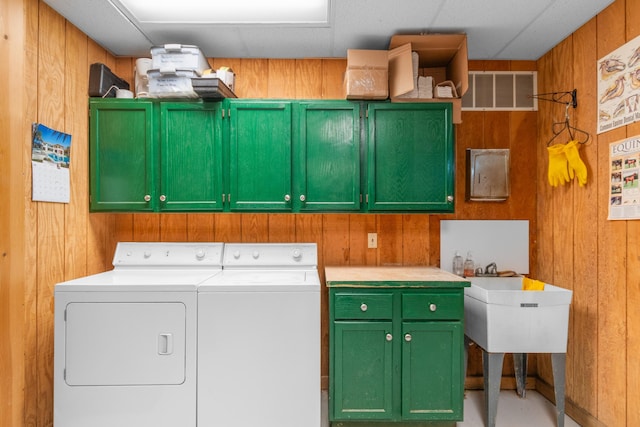 14091 Scio Church Rd, Chelsea, MI 48118 - laundry area with cabinet space, washing machine and clothes dryer, and wooden walls