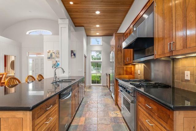 14091 Scio Church Rd, Chelsea, MI 48118 - kitchen with appliances with stainless steel finishes, range hood, brown cabinetry, stone tile floors, and recessed lighting