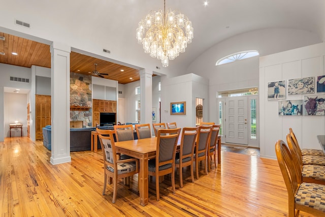 14091 Scio Church Rd, Chelsea, MI 48118 - dining area with ornate columns, light wood-type flooring, ceiling fan, high vaulted ceiling, and a chandelier