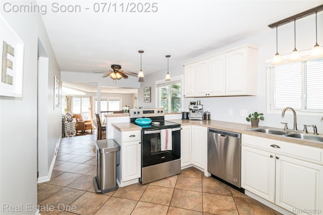8856 Charbane Ave, White Lake, MI 48386 - kitchen with stainless steel appliances, a peninsula, ceiling fan, light countertops, and white cabinets