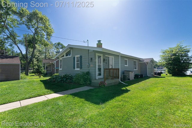 8856 Charbane Ave, White Lake, MI 48386 - view of front facade featuring a front yard and a chimney