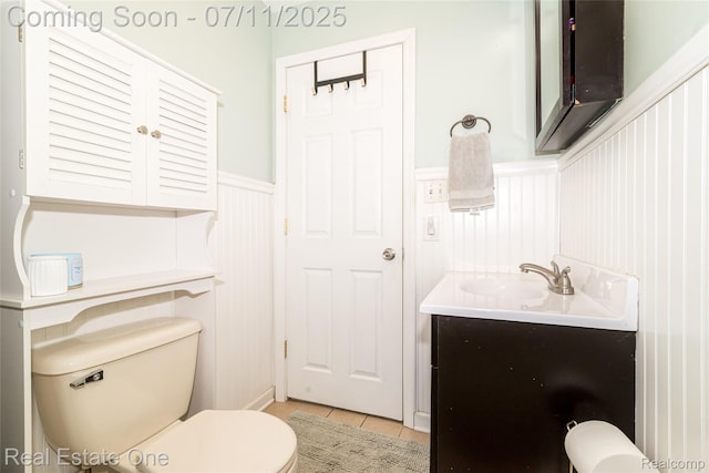 8856 Charbane Ave, White Lake, MI 48386 - bathroom featuring vanity, wainscoting, tile patterned floors, and a decorative wall