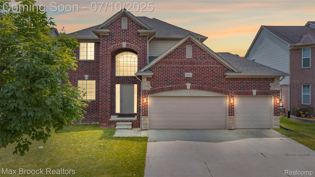 5142 Trailwood Ln, Warren, MI 48092 - traditional-style house with driveway, a front yard, an attached garage, and brick siding