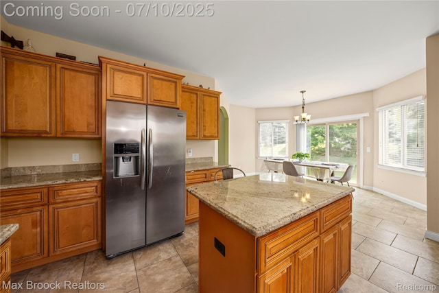 5142 Trailwood Ln, Warren, MI 48092 - kitchen featuring stainless steel fridge, brown cabinets, a chandelier, a center island, and light stone countertops