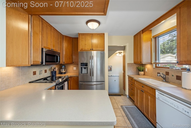 903 Oakridge Ave, Royal Oak, MI 48067 - kitchen featuring stainless steel appliances, light countertops, decorative backsplash, and light tile patterned flooring